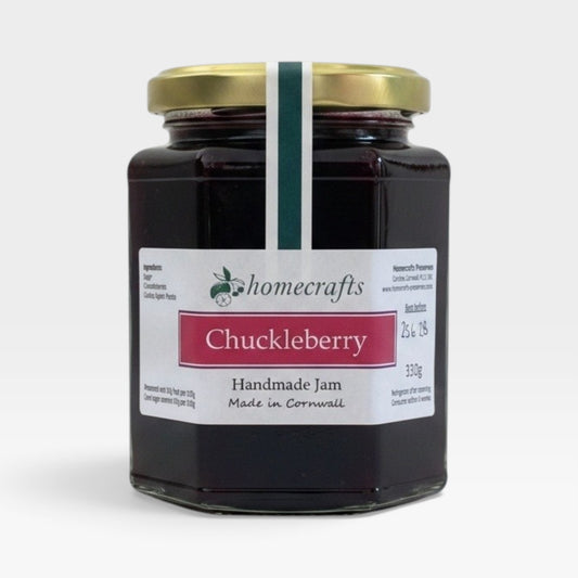 A glass jar of Homecrafts Chuckleberry Handmade Jam with a gold lid and white label, set against a plain light gray background.